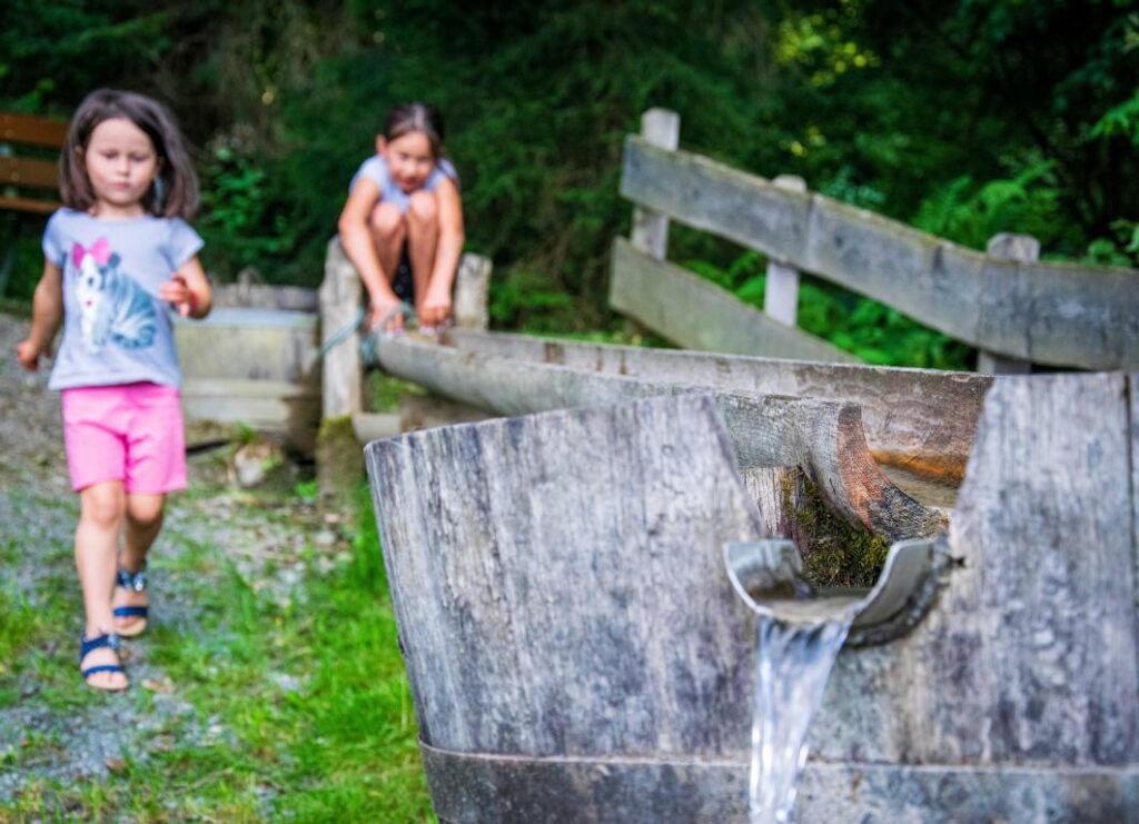 Kinder spielen am Brunnen